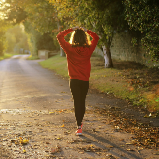 Persona corriendo en un entorno natural o bosque, practicando ejercicio.