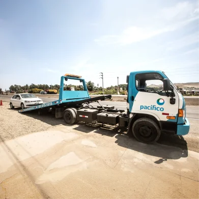 Grúa de Pacífico Seguros transportando un auto asegurado con seguro vehicular para reparación